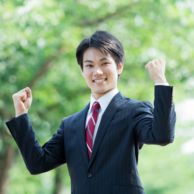 ガッツポーズをするスーツ姿の男性
