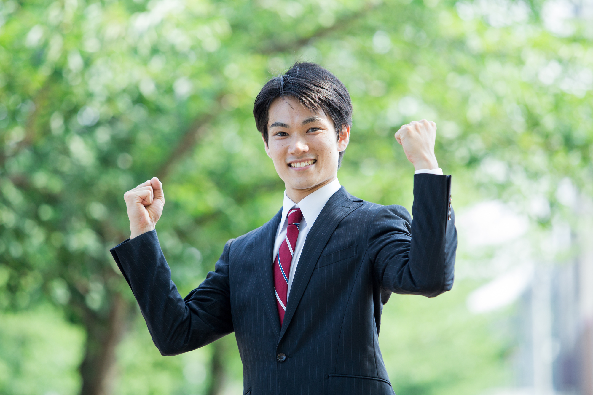ガッツポーズをするスーツ姿の男性