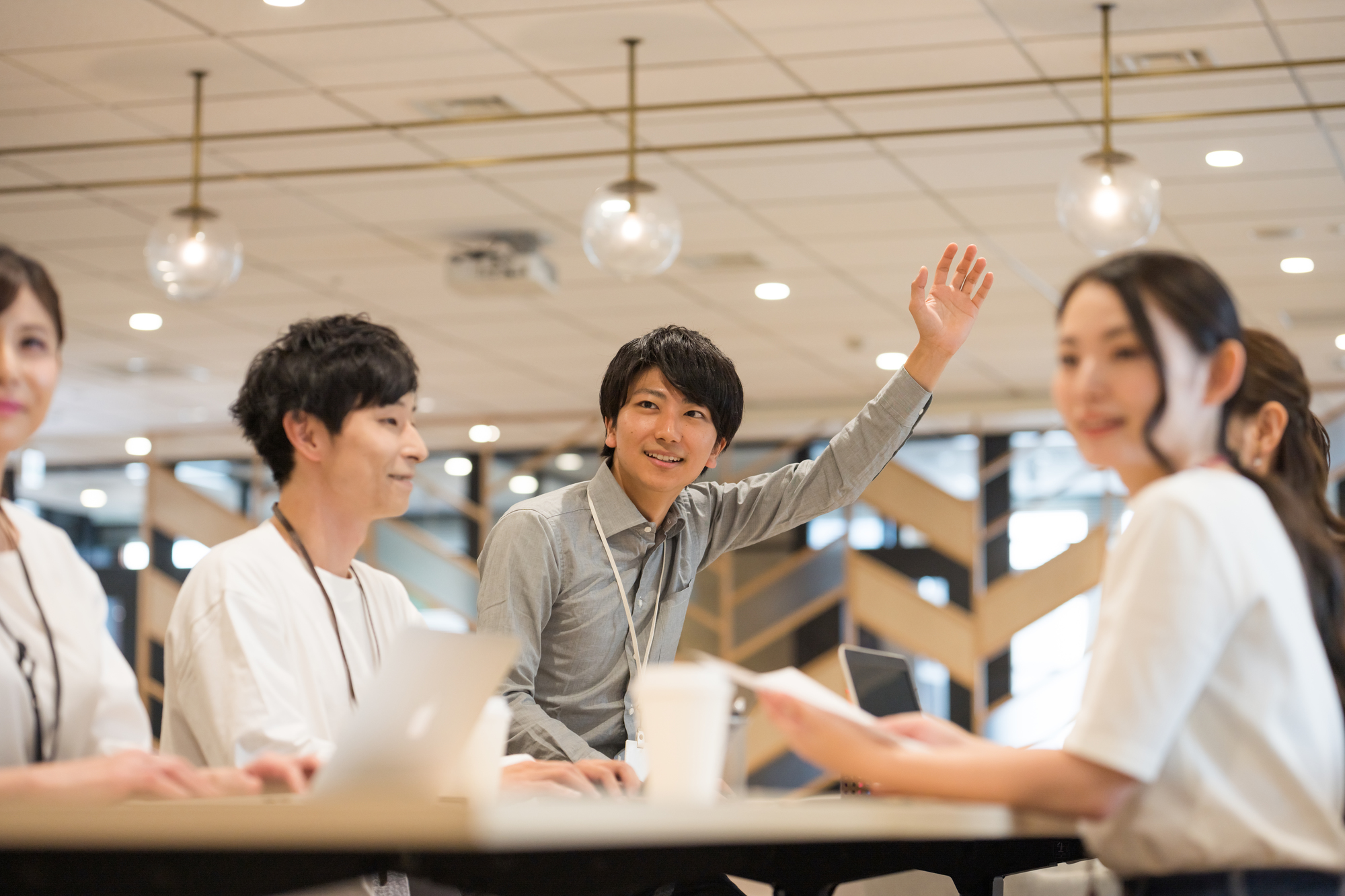 会議で挙手する男性