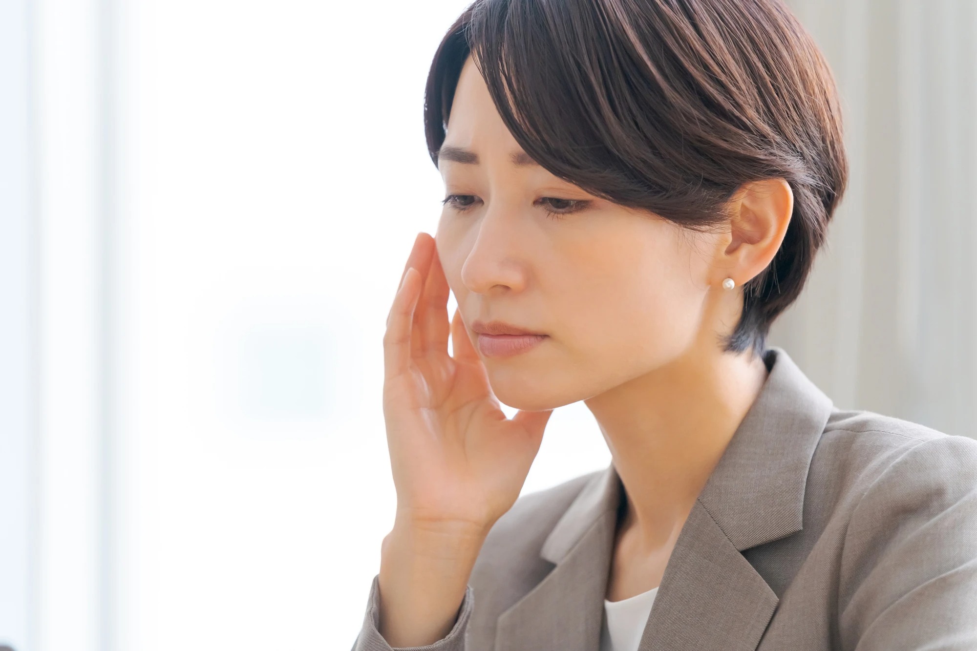 悩むスーツ姿の女性