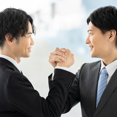 手を組んでいる2人の男性