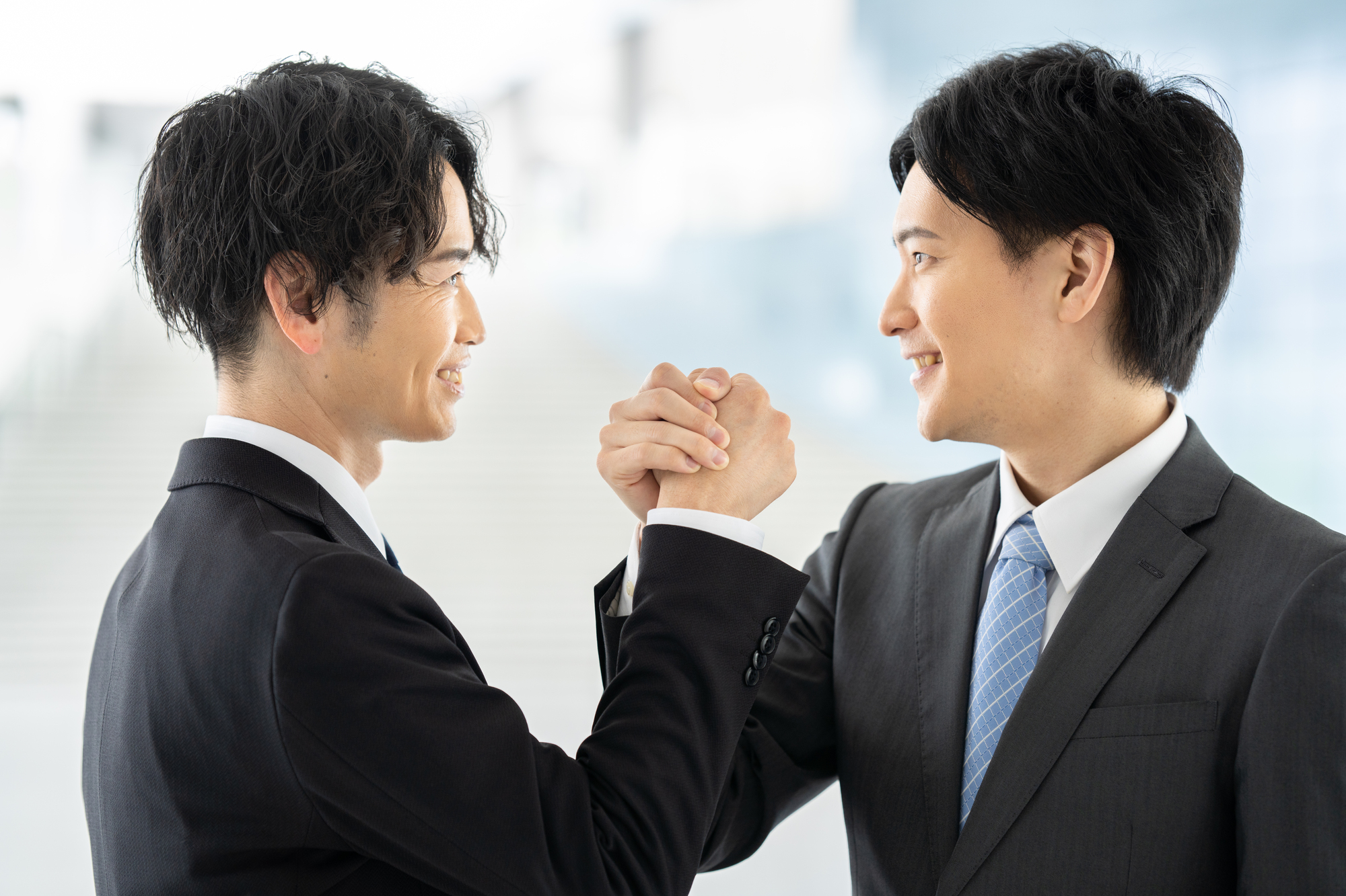 手を組んでいる2人の男性